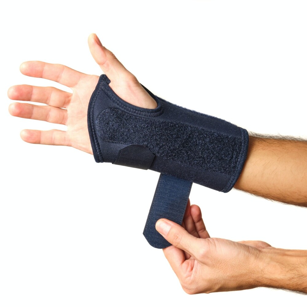 man's hands putting on a therapeutic wrist brace to relieve the pain of a sprain
